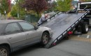 Car being loaded onto flat bed tow truck
