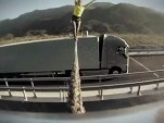 Faith Dickey walks a line strung between two moving Volvo trucks