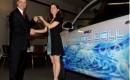 GM's Charlie Freese hands keys to a new fuel cell vehicle to Stephanie White