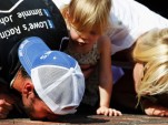 Jimmie, Genevieve Marie and Chandra Johnson kiss Indy's bricks - NASCAR photo