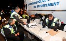 Police officers run identity checks at a sobriety checkpoint in Escondido, CA
