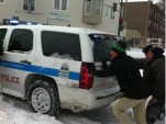 Rahm Emanuel helps push a police vehicle out of the snow