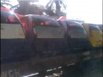 Tata Nanos shipped sideways on flatbed rail car outside Bangalore, India, from YouTube user Auroajay